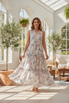 Confident woman wearing a flowy sleeveless tiered maxi dress in a bright summer setting